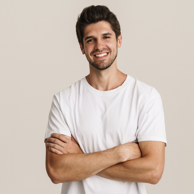 Férfi model visel kényelmes pólót és nadrágot egy világos háttér előtt, egyszerű és stílusos megjelenéssel.