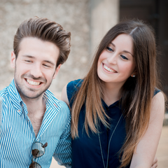 Felnőtt nő mesefigurás pizsamában mosolyogva ül egy kanapén, kezében bögre, háttérben színes párnák és mesés dekorációk.