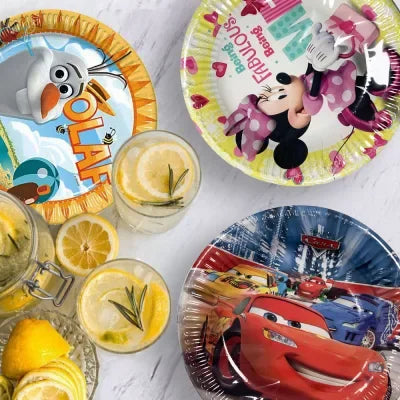 Színes Disney mintás papírtányérok gyerek születésnapi asztalon.
