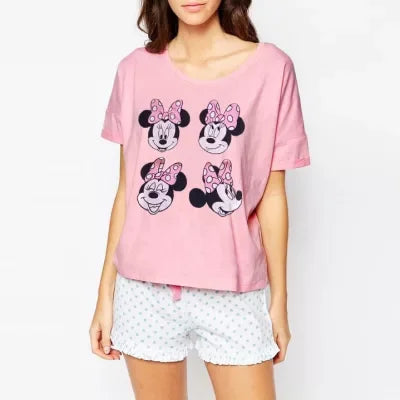 Nő visel Disney mintás, színes és kényelmes pólót egy vidám, mesés háttér előtt.